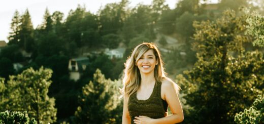 woman standing in front of trees during sunset