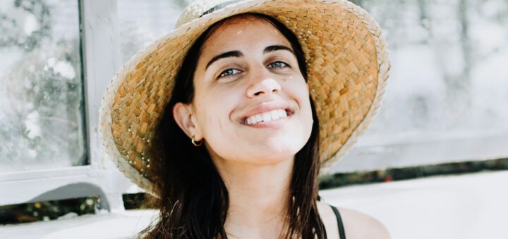 woman wearing black strap top with sunhat