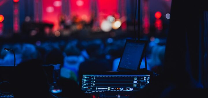 a stage with a laptop and microphone in front of a crowd