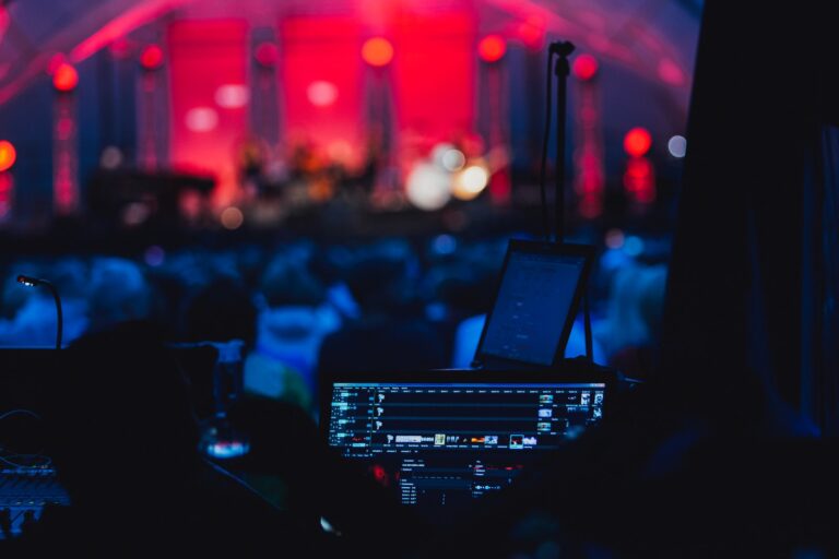 a stage with a laptop and microphone in front of a crowd
